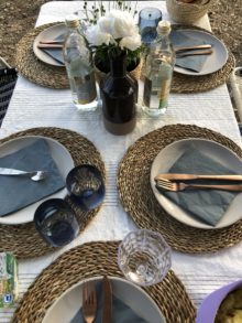 Camping Geschirr Tipps. schön gedeckter Tisch mit Bast Untersetzern und schwarzen Tellern